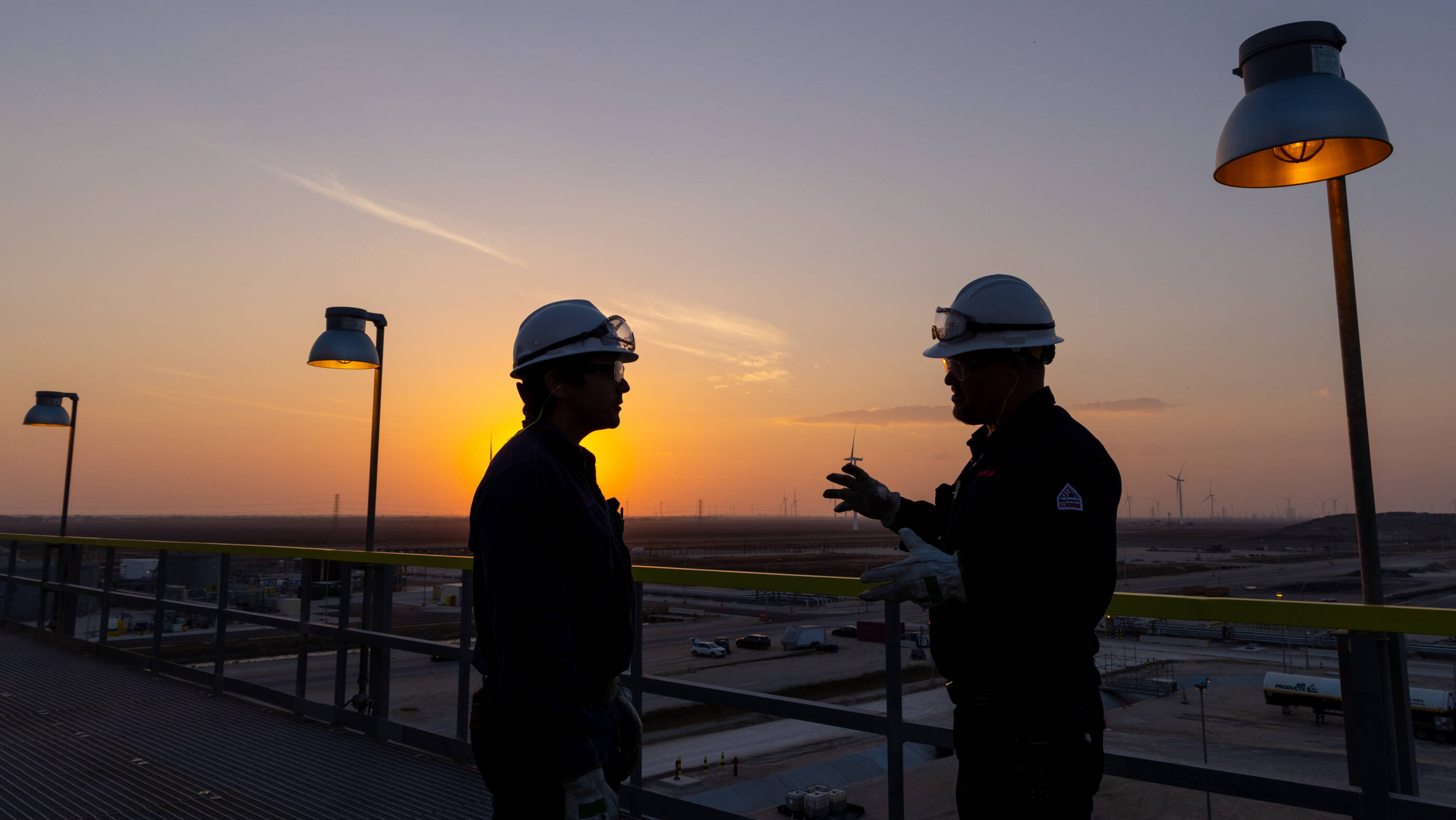 Two employees wearing hard hats and safety goggles